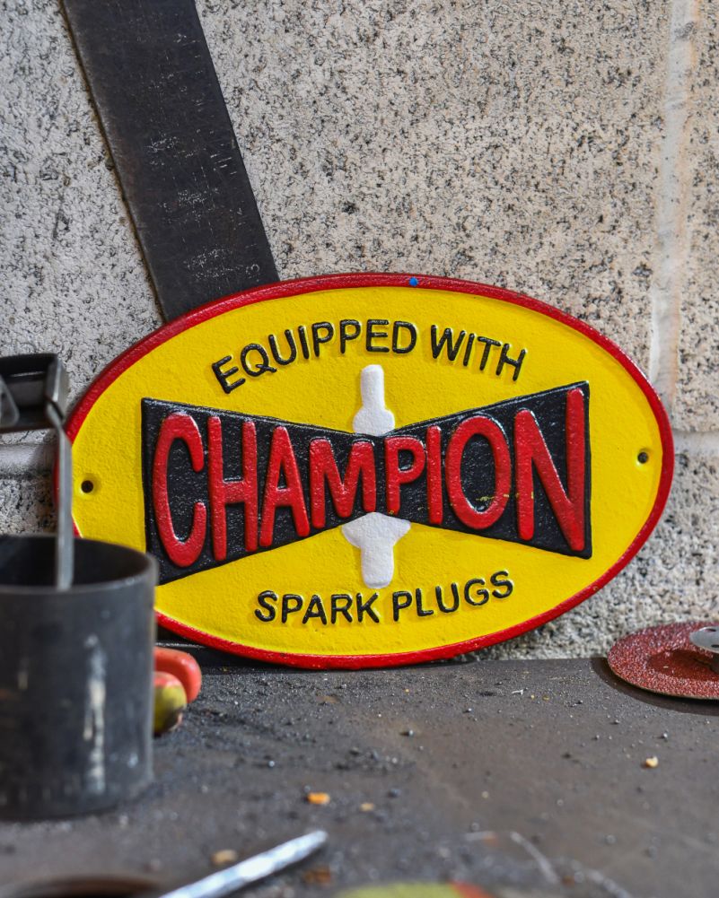 Champion Spark Plugs Cast Iron Automobilia Sign In A Setting
