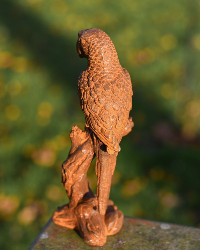 Rustic cast iron parrot on branch