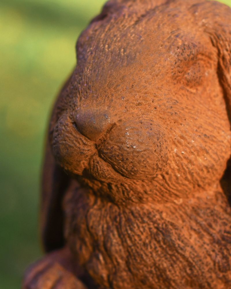 Rustic cast iron rabbit garden sculpture close up