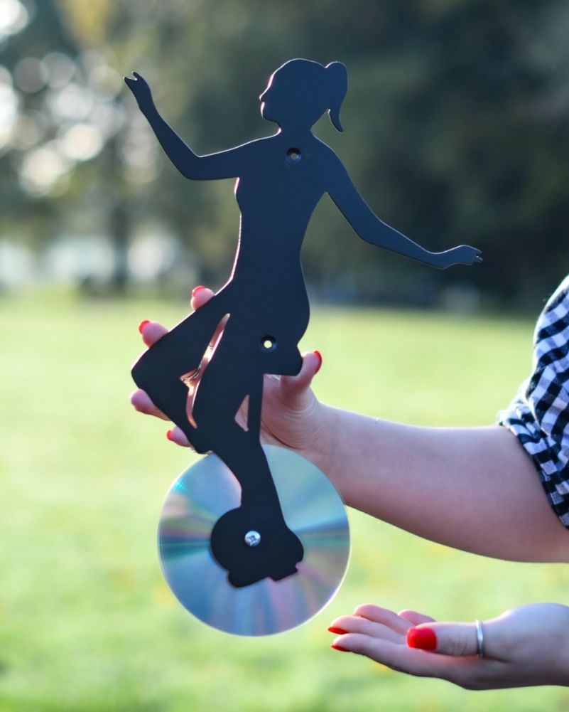 Steel Unicycle Recycled CD Black Wall Art in a Grassy Setting