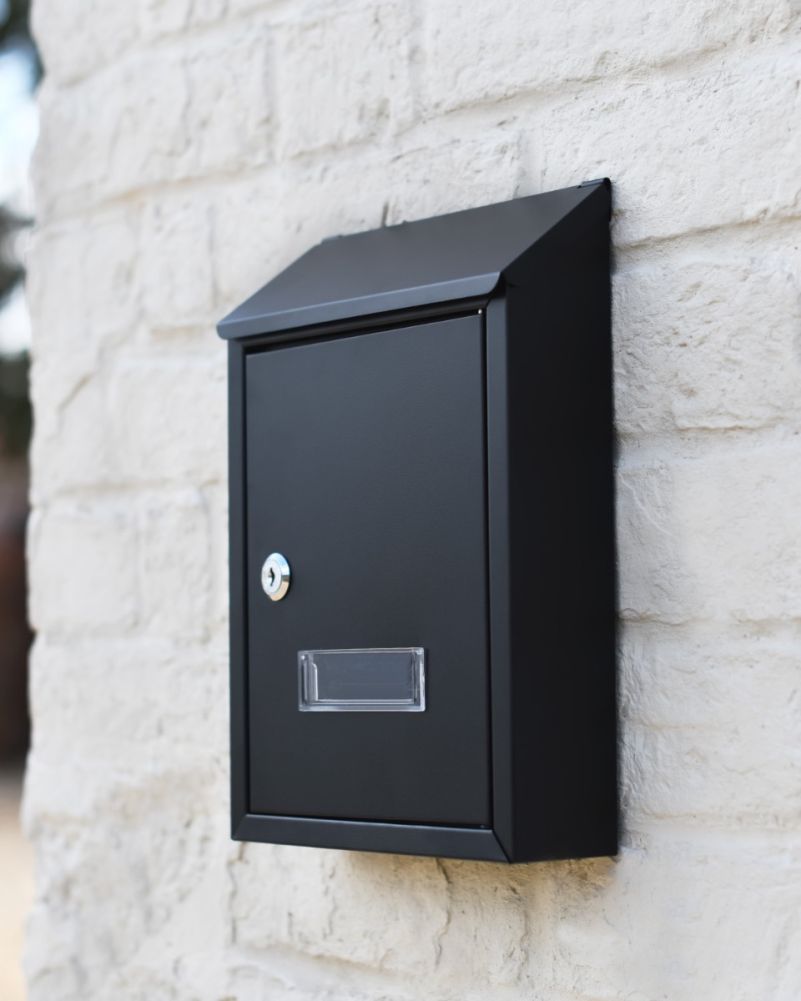 Steel Wall Mounted Contemporary Slanted Post Box In Black On A Home Exterior