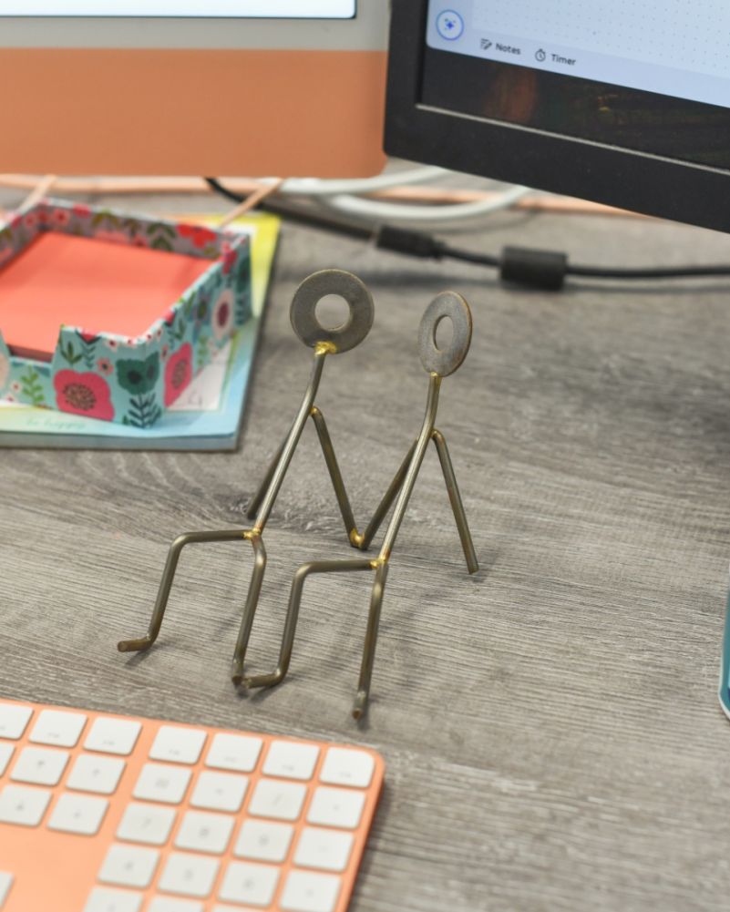 The 'Happy Couple' Scrap Metal Art Phone Holder In The Setting