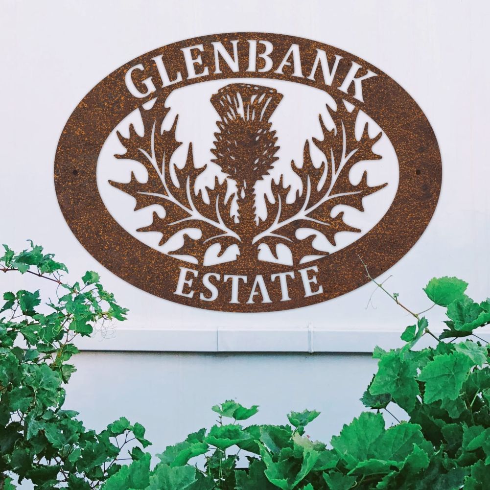 Rustic Thistle Oval House Name Sign On a White Wall