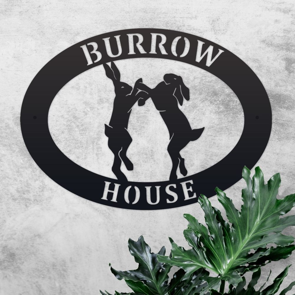 Boxing Hares Oval House Name Sign On a Rustic Wall