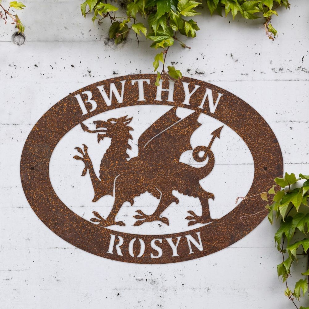 Rustic Welsh Dragon Oval House Name Sign On a White Brick Wall