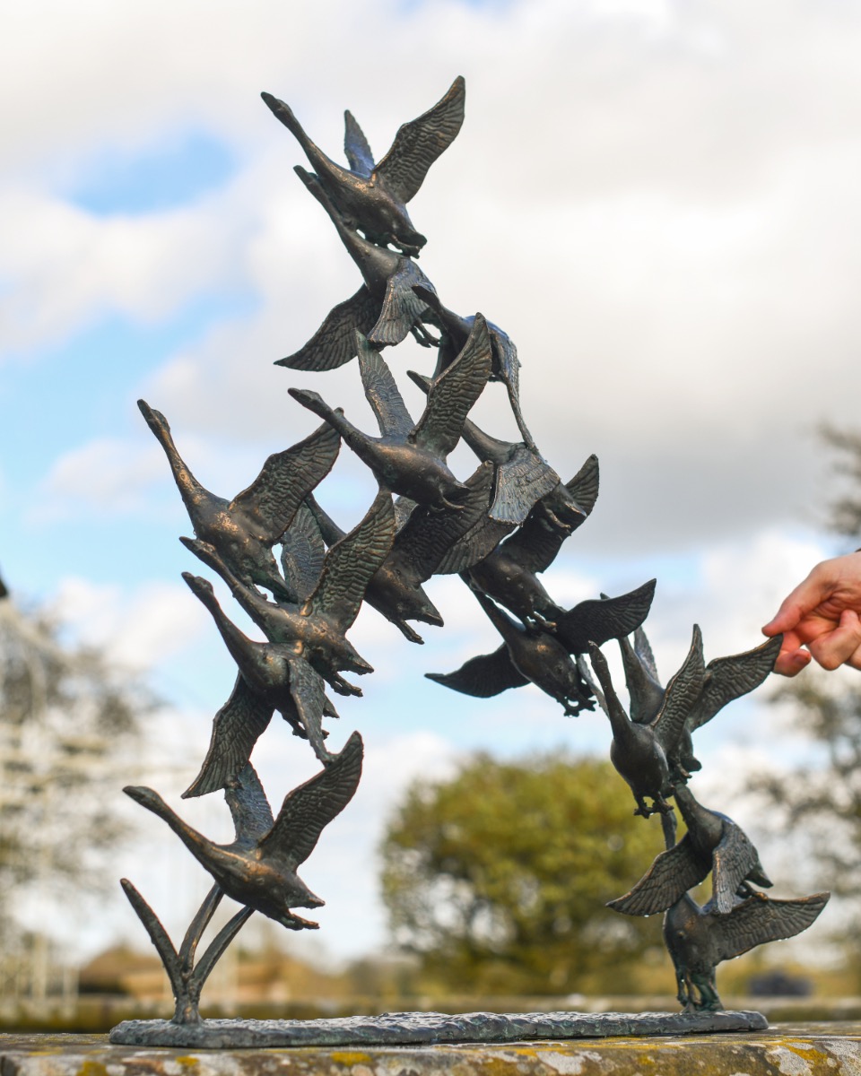 Flock Of Birds Garden Sculpture Next To Hand For Scale